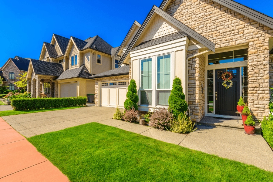 large luxurious homes next to each other in a neighborhood with beautiful landscaping